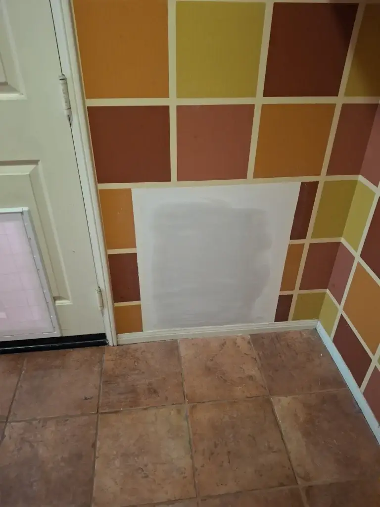 Patched dog door opening in colorful wall